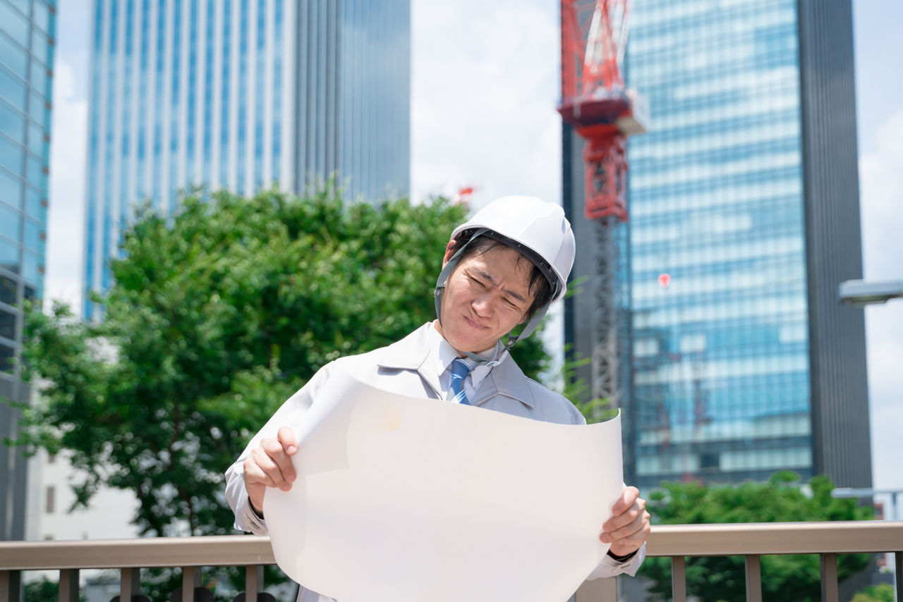 ビジネスマン・図面を見て悩む