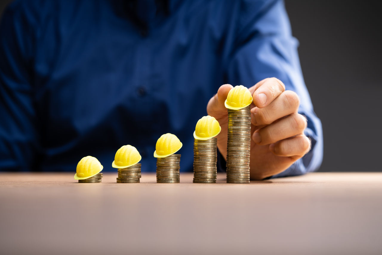 Construction Insurance And Budget Inflation. Coin And Hard Hat