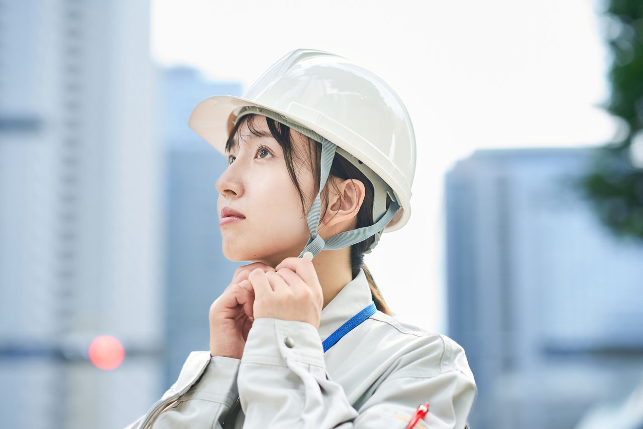 作業服とヘルメットを着用した若い女性