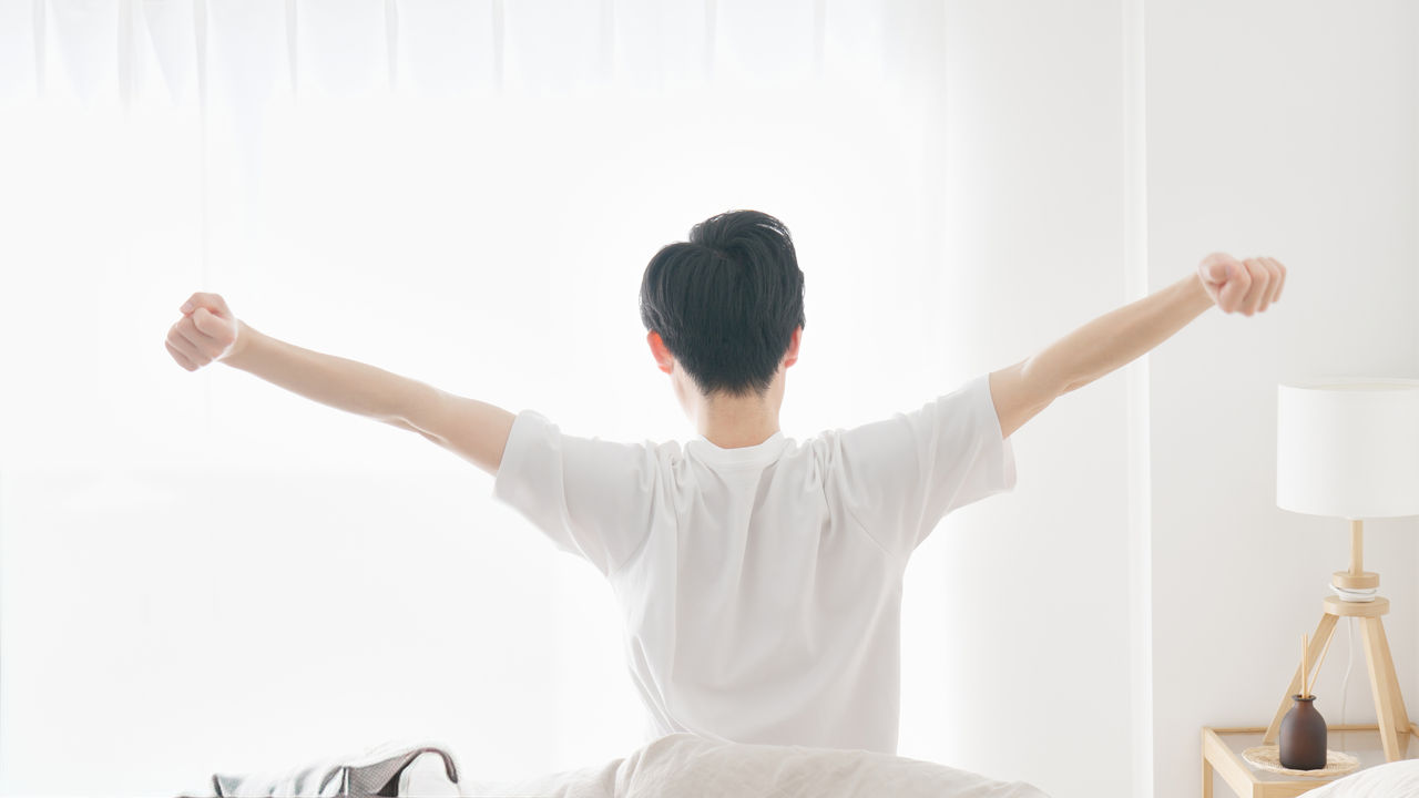 A man wakes up and stretches