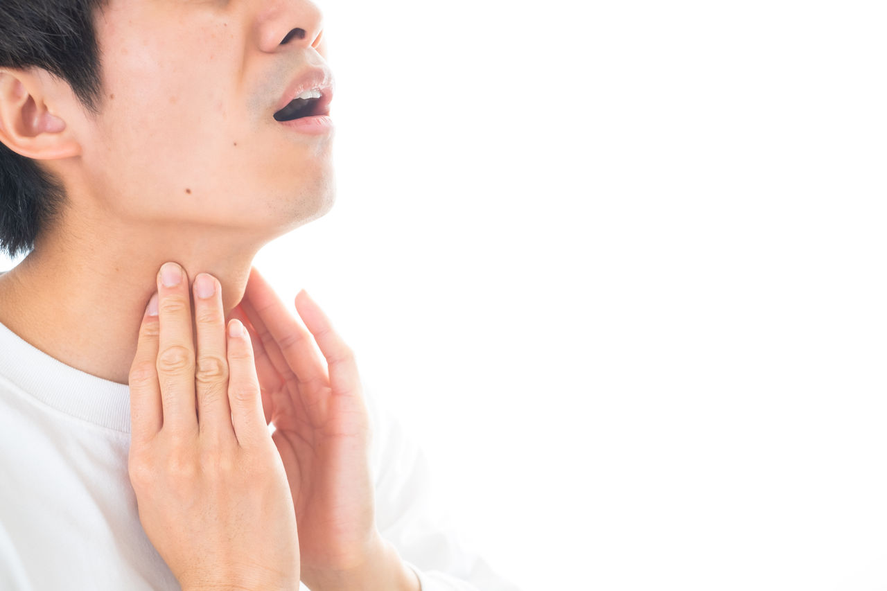 喉が痛くて辛そうな男性