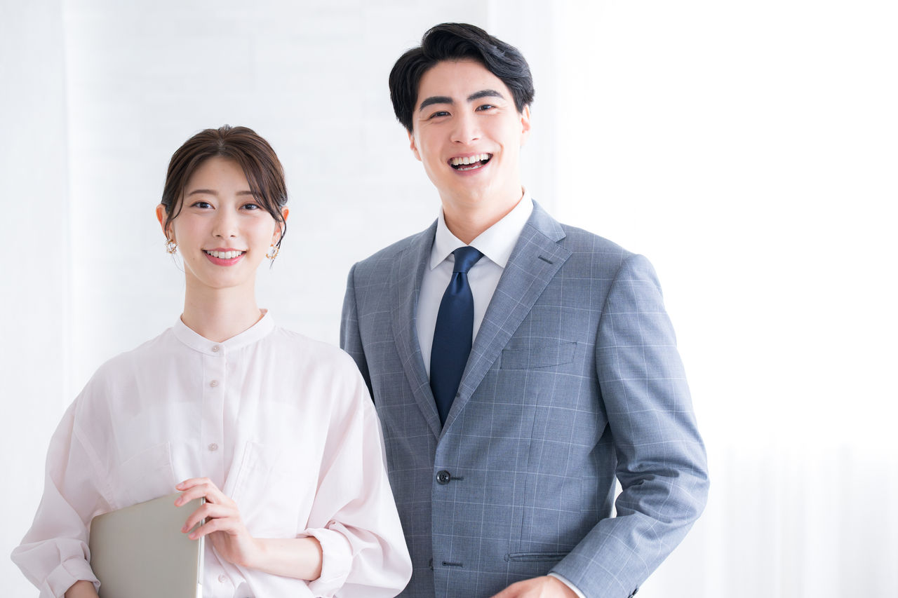 スーツ姿でカメラ目線のビジネスマン男女