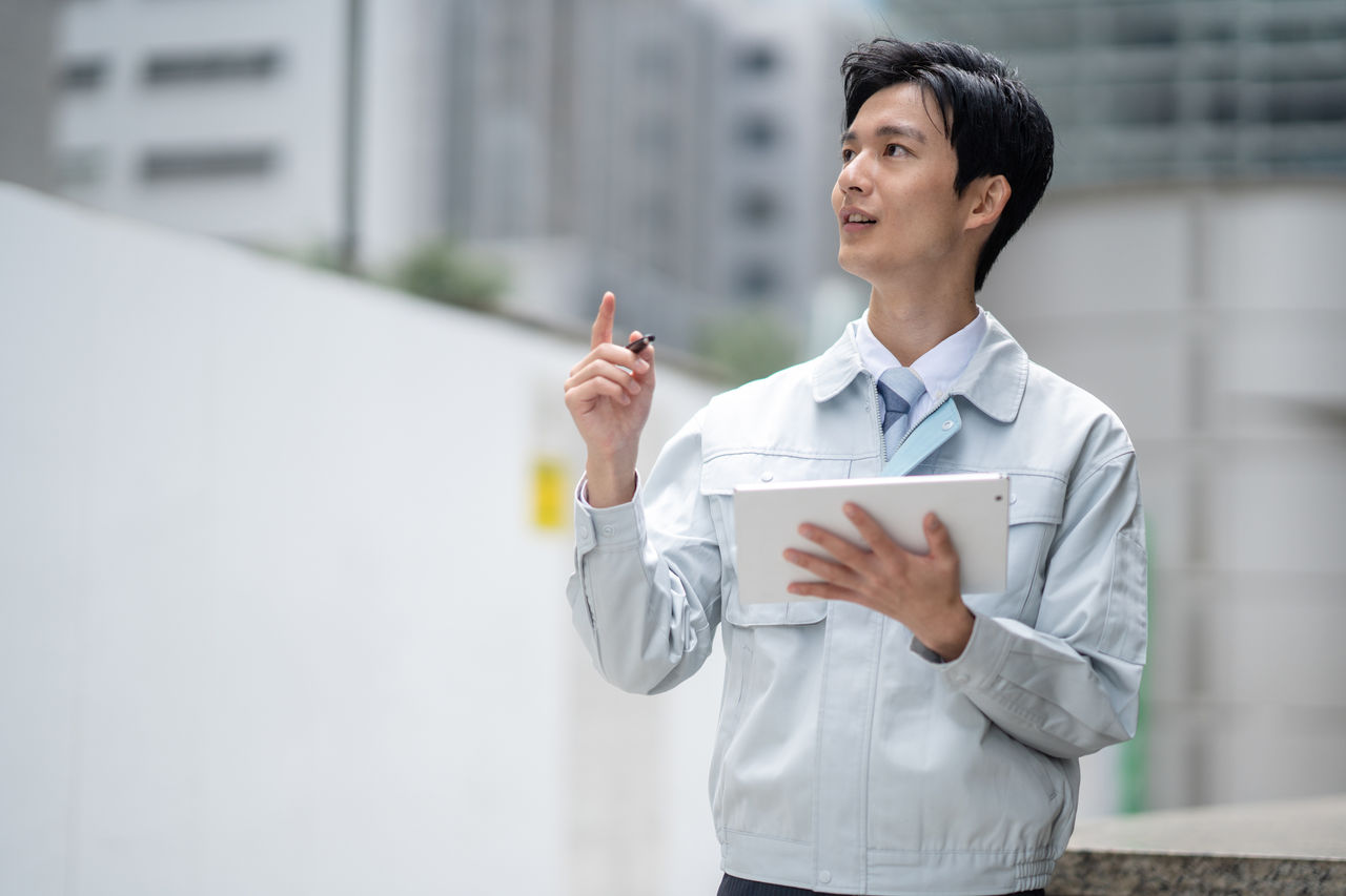 タブレットを持つ作業着の男性