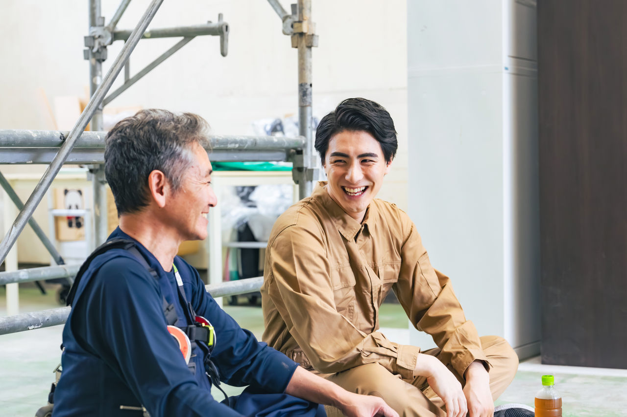 作業員、休憩、仕事、業者、施工、工事、建築、現場、大工、職人、エンジニア、談笑、会話、昼休み、笑顔、親方、棟梁、改装、リフォーム、内装、塗装、労働者、肉体労働、シニア、世代、笑う、楽しい、やりがい、ポジティブ、充実、リラックス、満足、職場、足場、解体、インフラ、建設、工場、アルバイト、スポットワーク、スキマバイト、日雇い、労働、作業服、下請け、社員、人材、雇用、鳶職、人物